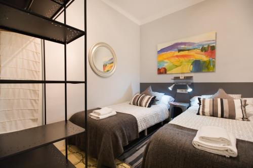 a small room with two beds and a mirror at Barcelona 54 Apartment Rentals in Barcelona