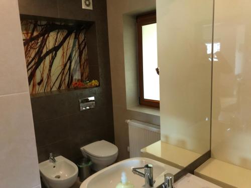a bathroom with a sink and a toilet and a mirror at Bystra Woda Apartament Słoneczny in Zakopane