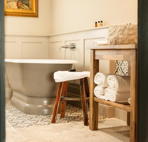 a bathroom with a tub and a sink at The Greyhound on the Test Hotel in Stockbridge