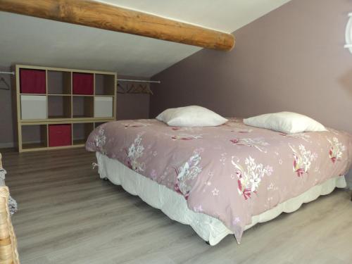 um quarto com uma cama com um cobertor rosa em Gite touristique em Piolenc