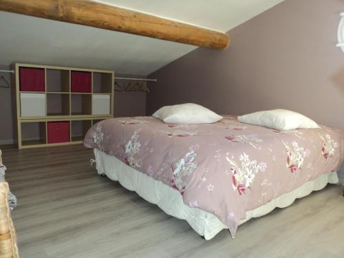 une chambre avec un lit avec une couverture rose dans l'établissement Gite touristique, à Piolenc