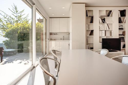 Oliveto Lario的住宿－Villa Sara Lakeside，白色的用餐室配有桌椅