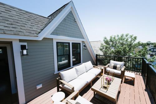 a patio with a couch and chairs on a deck at The Newport Lofts - 595 Thames Street in Newport