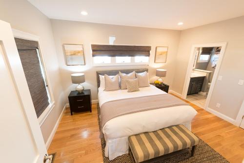 a bedroom with a large bed and two windows at The Newport Lofts - 595 Thames Street in Newport