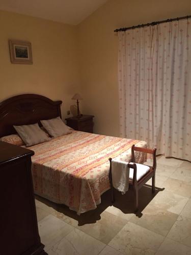 コラレホにあるURBANIZACIÓN CÓRDOBAのベッドルーム1室(ベッド1台、椅子、窓付)