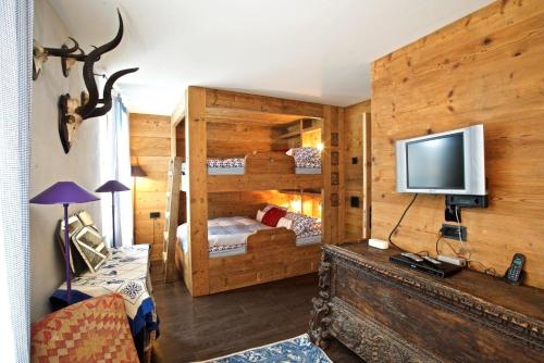 een slaapkamer met 2 stapelbedden en een televisie bij chesa la posta in Samedan