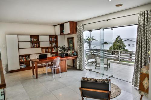 a living room with a desk and a balcony at Sea Dreams Guesthouse in Ballito