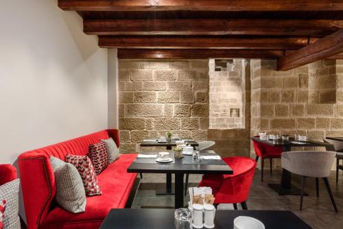 a restaurant with red furniture and a brick wall at Eurostars Fuerte Ruavieja in Logroño