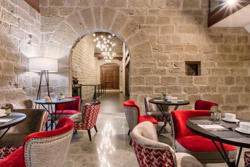 a restaurant with red chairs and tables and a brick wall at Eurostars Fuerte Ruavieja in Logroño
