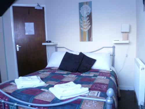 a bedroom with a bed with towels on it at Belle Vue Hotel in Llanwrtyd Wells