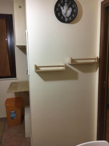 a clock is on the wall above a toilet at Residence K.B. 2 in Fano