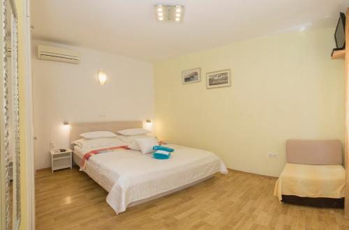 a bedroom with a white bed and a chair at Central Old Town Rooms in Split