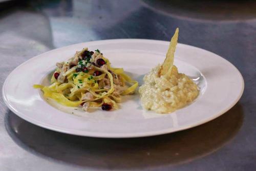 a plate of food with pasta and sauce on a table at Hotel Fantelli in Folgarida