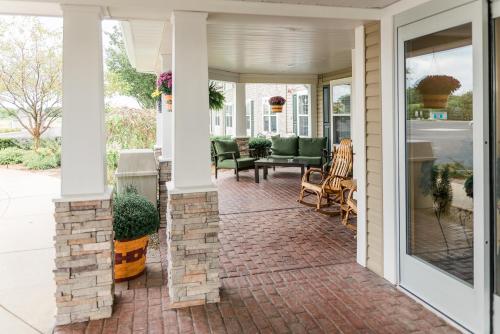 a porch with a brick walkway with chairs on it at Van Buren Hotel in Shipshewana