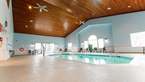 a swimming pool in a large room with a wooden ceiling at Van Buren Hotel in Shipshewana