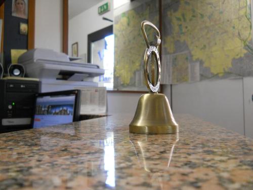 a brass bell sitting on top of a counter at Hotel Iride stazione Lambrate Città studi in Milan
