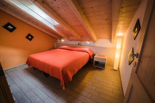 a bedroom with a red bed in a attic at Chalet Val Concei in Lenzumo di Concei