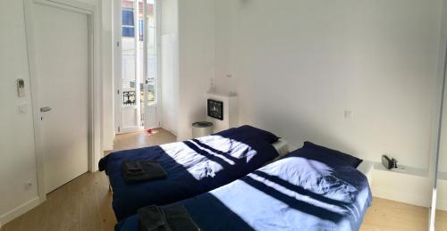 une chambre avec deux lits avec des draps bleus et blancs dans l'établissement Apartment on Place Massena, à Nice