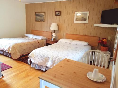 a hotel room with two beds and a table at Black Bear Lodge in Prattsville