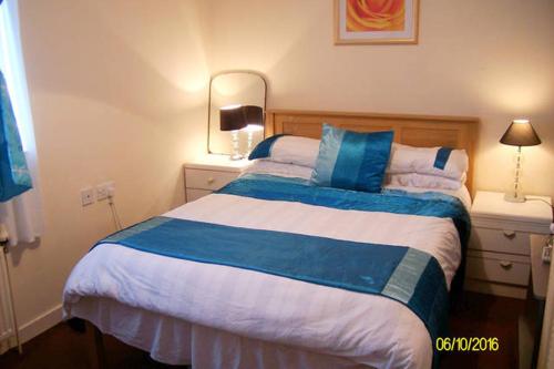 a bedroom with a large bed with blue and white sheets at Eagles Land in Edinburgh