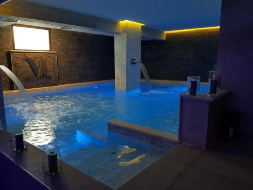 a large swimming pool with blue lights in a building at Villa Minieri Resort & SPA in Nola