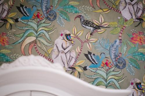 a bathroom with a wallpaper with birds and flowers at Grange Boutique Hotel in Grange Over Sands