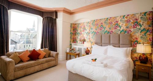 a bedroom with a large bed and a couch at Grange Boutique Hotel in Grange Over Sands