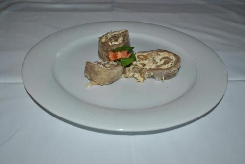 a white plate with a piece of food on it at Marinčič Inn in Škocjan