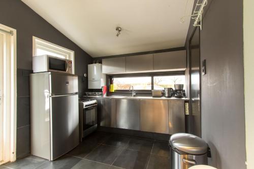 a kitchen with a stainless steel refrigerator and a window at Garden House, Private studio apartment with wifi and free parking for 1 car in Weesp