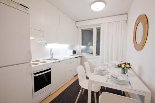 ロヴァニエミにあるSanta's apartment 2の白いキッチン(白いテーブルと椅子付)
