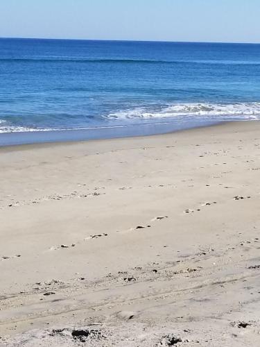 a beach with footprints in the sand and the ocean at Ocean Pines Resort in Duck