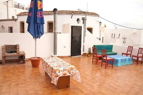 eine Terrasse mit einem Tisch, Stühlen und einem Sonnenschirm in der Unterkunft Vivienda Rural El Mirador de Enix in Enix
