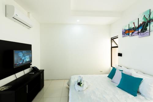 a bedroom with a bed with blue pillows and a tv at Apartamentos La Casona in Fortuna
