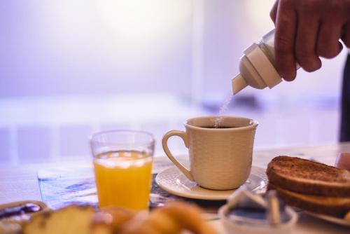 a person pouring coffee into a cup on a table at San Rafael Group Hotel in San Rafael