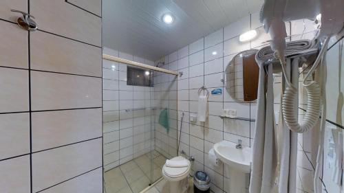 a small bathroom with a toilet and a sink at Hotel Joao de Barro in Itajaí