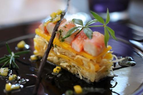 a piece of cake with fruit on a plate with a fork at Hotel restaurant Spa Disini Montpellier Est, The Originals Relais in Castries