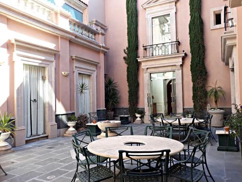 un patio con mesas y sillas en un edificio en Casa Toscana Bed & Breakfast en San Miguel de Allende