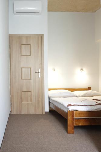 a bedroom with a bed and a wooden door at Rest- Pokoje z Łazienkami in Gdynia