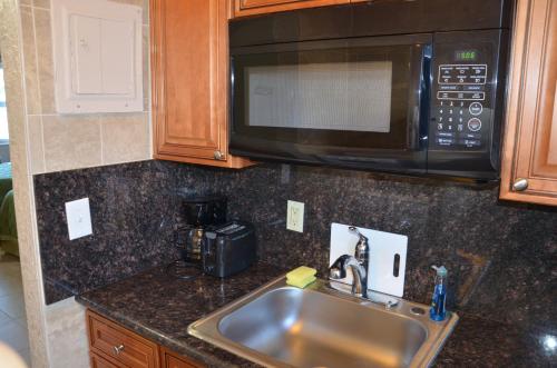 a kitchen counter with a sink and a microwave at La Terrace Oceanfront in Hollywood