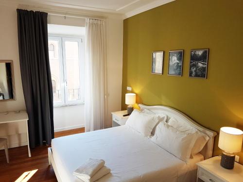 um quarto com uma cama branca e uma janela em More Cola di Rienzo B&B em Roma