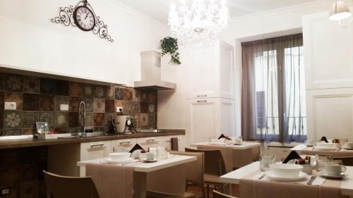 um restaurante com mesas e cadeiras brancas e um lustre em More Cola di Rienzo B&B em Roma