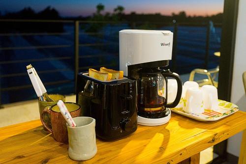 Dorami Pension في سيوجويبو: آلة صنع القهوة موضوعة على طاولة عليها طعام