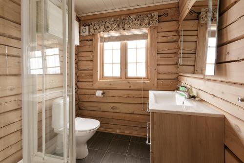 a bathroom with a toilet and a sink and a window at Røde Kors in Brunstad