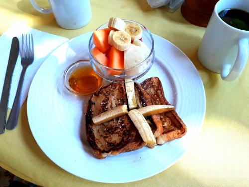 a plate of food with french toast and bananas and fruit at Hotel La Polvora in Granada