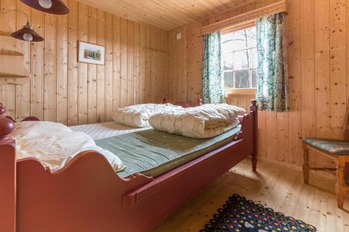 ein Schlafzimmer mit einem Bett in einem Holzzimmer in der Unterkunft Sjåfram in Stranda