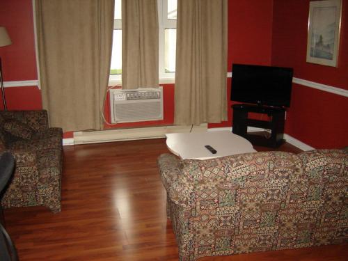 a living room with a couch and a tv at Days Inn by Wyndham Trois-Rivieres in Trois-Rivières