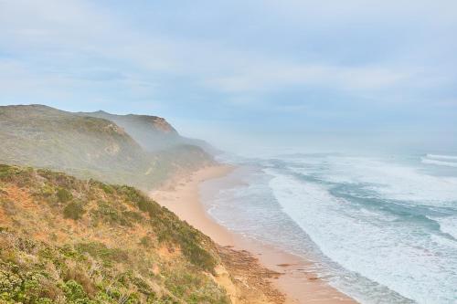 
a sandy beach with a view of the ocean at Great Ocean Walk Retreat in Glenaire
