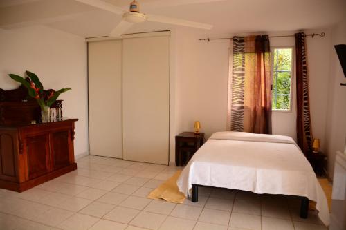 a bedroom with a bed and a window at Villa Campêche in Les Trois-Îlets