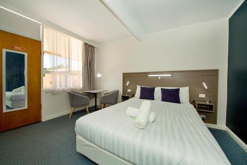 Habitación de hotel con cama grande y escritorio. en Motel Yarrawonga, en Yarrawonga