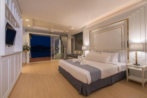 a bedroom with a large bed and a large window at Raya Buri Resort Kanchanaburi in Si Sawat